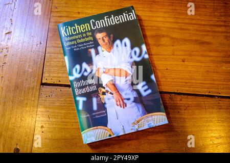 NEW ORLEANS, LA, USA - 28. APRIL 2023: Titelseite des Buchs „Kitchen Confidential: Adventures in the Culinary Underbelly“ auf einem hölzernen Tisch Stockfoto