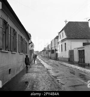 Sibiu County, Sozialistische Republik Rumänien, ca. 1977. Menschen an der Hauptstraße einer Siebenbürgen-Stadt an einem kalten Wintertag. Stockfoto