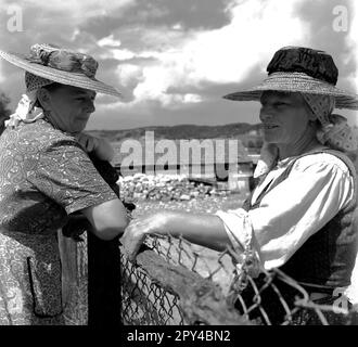 Sibiu County, Sozialistische Republik Rumänien, ca. 1976. Zwei einheimische Frauen aus der sächsischen Gemeinde tragen ihre Arbeitskleidung und traditionelle Strohhüte. Stockfoto