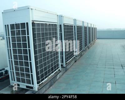 Industrielle Klimaanlagen-Kondensatoren (Außeneinheit) auf dem Dach des Bürogebäudes. Stockfoto