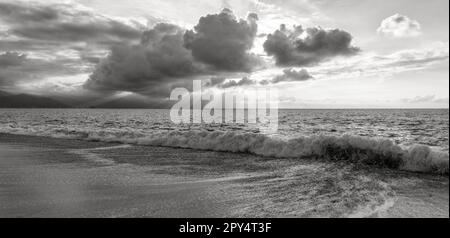 Ein Sonnenuntergang Im Ozean Mit Sonnenstrahlen Hinter Den Wolken, Schwarz-Weiß-Banner Stockfoto