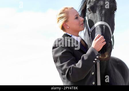 Pferd, Sport und Frau auf Pferdetraining und Wettkampfplatz mit blauem Himmel. Draußen, Sonnenbär, weibliche Wettkämpferin und Pferde mit einem Reiter auf Stall Stockfoto