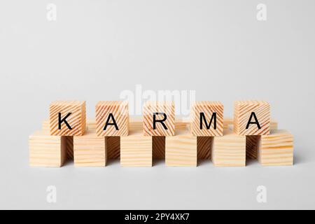 Wort Karma aus Würfeln mit Buchstaben auf hellem Hintergrund Stockfoto