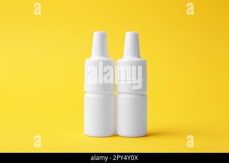 Flaschen medizinischer Tropfen auf gelbem Hintergrund Stockfoto