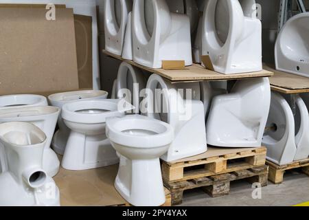 Viele weiße Toiletten im Baumarkt, in der Klempnerabteilung Stockfoto