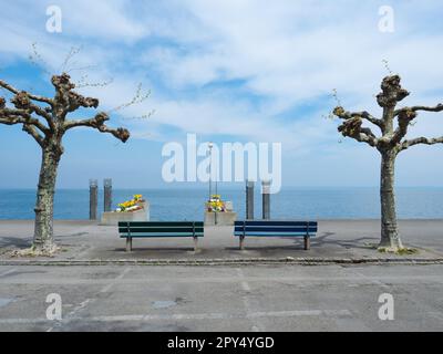 Rorschach, Schweiz - April 22. 2022: Zwei Bänke am Ufer des Bodensees. Stockfoto