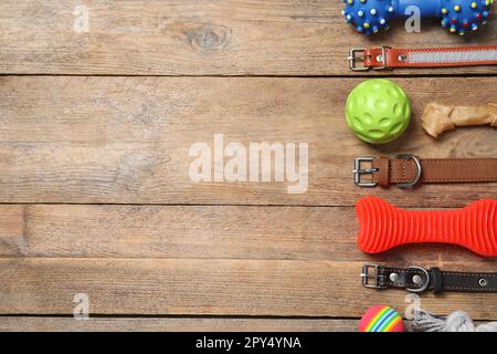 Flache Liegezusammensetzung mit Hundehalsband und Spielzeug auf Holztisch. Platz für Text Stockfoto