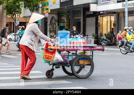 Traditioneller Straßenverkäufer mit Bambushut und Schubwagen, Ho-Chi-Minh-Stadt, Vietnam Stockfoto