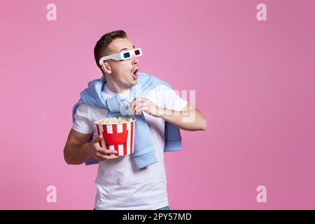 Ein verängstigter Mann in 3D-Brillen mit einem Eimer Popcorn Stockfoto