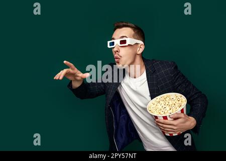 Ein Mann in 3D-Brille mit einem großen Eimer Popcorn Stockfoto