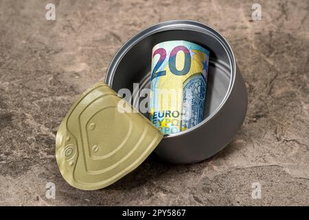 Zwanzig Euro in einer Blechdose, die auf den Steinhintergrund fällt Stockfoto