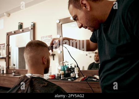 Friseur rasierender Weißer im Friseursalon Stockfoto