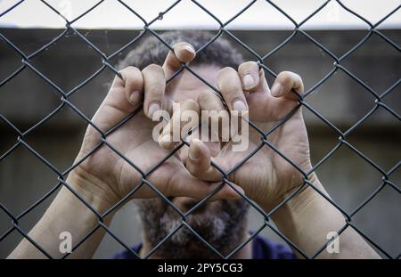 Die Hände eines Mannes auf einem Zaun Stockfoto