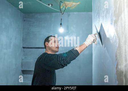 Mann isoliert eine Badezimmerwand Stockfoto