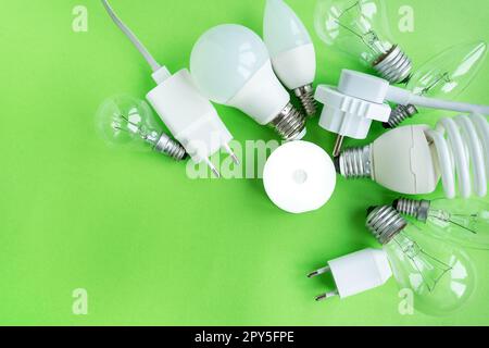 Ein Satz verschiedener LED-Lampentypen, isoliert auf grünem Hintergrund. Energiesparlampen, in der Mitte ist die Taschenlampe in der Mitte eingeschaltet. Stockfoto