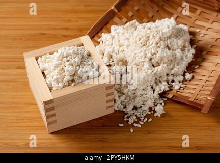 Reis-Koji in einem Sieb und Masu auf dem Tisch. Stockfoto