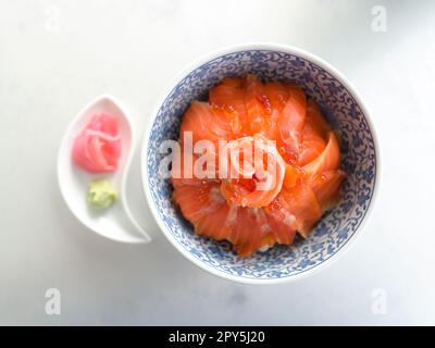 â Nahaufnahme in Scheiben â €€ Lachs und Lachs Rogen (Ikura) in einer Schüssel aus Sashimi-Reis. Stockfoto