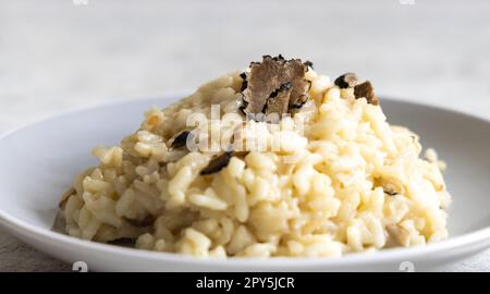 Risotto mit Porcini-Pilzen und schwarzen Trüffeln, serviert auf einem Teller mit Blick von oben, Gourmet-Cousine Stockfoto