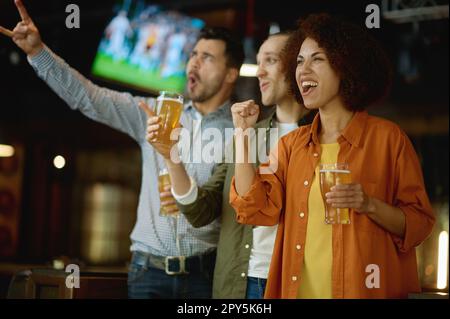 Glückliche Fußballfans trinken Bier und feiern den Sieg in der Sportbar Stockfoto
