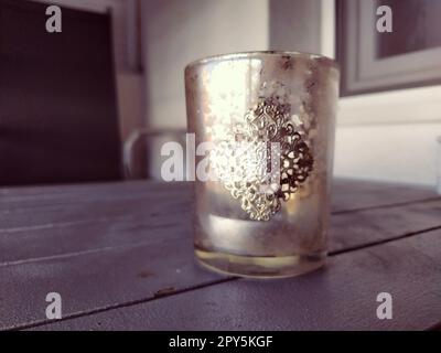 Glasbecher mit goldenem kunstvollem Muster. Wunderschöne Ornamente im orientalischen Stil auf den Gerichten. Eine Schüssel oder Tasse auf einem grauen Planktisch. Einrichtungsgegenstände und Innenelemente. Stockfoto