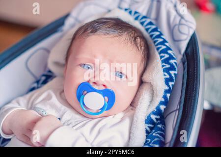 Nahporträt eines weißen Neugeborenen mit Schnuller im Mund Stockfoto