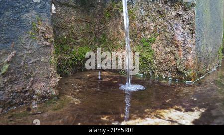 Banja Koviljaca, Serbien, Guchevo, Loznica. Frühling drei Quellen. Heilendes natürliches Mineralwasser aus dem Berg Guchevo. Moos und Flechten auf dem Felsen. Wassertropfen. Stockfoto