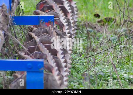 Blaue schwere landwirtschaftliche Geräte wie Pflug mit scharfen Stahlscheiben für den landwirtschaftlichen Ackerbau mit traktorgezogenen Geräten zur Vorbereitung der Feldarbeit erleichtern die Mechanisierung harter Landwirtschaftsarbeiten Stockfoto