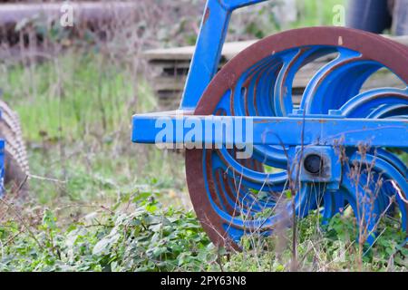 Blaue schwere landwirtschaftliche Geräte wie Pflug mit scharfen Stahlscheiben für den landwirtschaftlichen Ackerbau mit traktorgezogenen Geräten zur Vorbereitung der Feldarbeit erleichtern die Mechanisierung harter Landwirtschaftsarbeiten Stockfoto