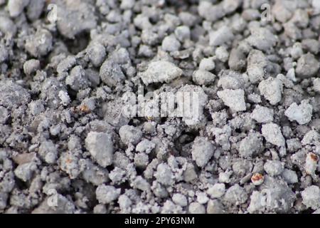 Graue rohe Steine und Rohsteine als Natursteinhintergrund mit zerkleinertem und rauem Material als Baumaterial oder felsiger Boden für Betonmischungen in grauen Farben als Natursteinhintergrund Stockfoto