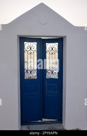 Geschlossene blaue Tür, ein traditionelles Stück Architektur auf der Insel Santorin. Griechenland Stockfoto