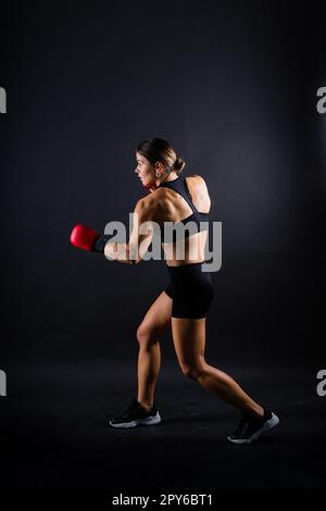 Frau macht High-Kick, Tae-bo. Sportliche Passform für Damen mit perfektem Körperkick und Schlägen mit den Beinen Stockfoto