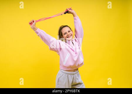 Bezauberndes weibliches Kind mit Seilspringen im Studio Stockfoto