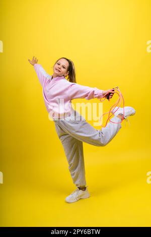 Bezauberndes weibliches Kind mit Seilspringen im Studio Stockfoto