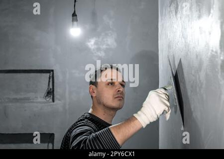 Mann isoliert eine Badezimmerwand Stockfoto