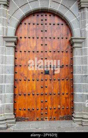 Alte, riesige Holztür in einer Steinwand einer Kirche. Stockfoto