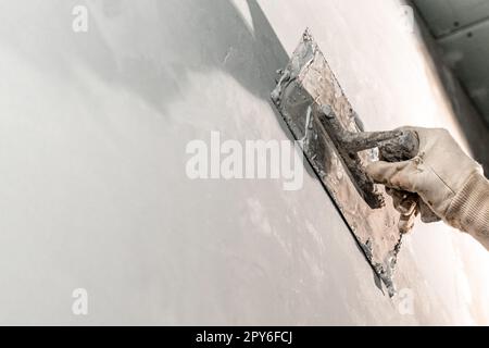 Handarbeit mit einer Kelle zum Abdichten der Wand Stockfoto