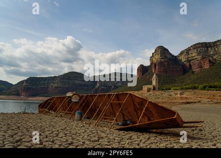 Sau, Spanien - 28. April 2023: Am Sau-Reservoir wird ein altes Boot gesehen, da die durch den Klimawandel verursachte Dürre zu Wasserknappheit in Spanien und in Europa führt Stockfoto