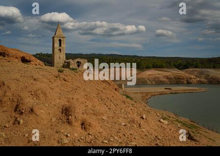Vilanova de Sau, Spanien - 28. April 2023: Der Glockenturm von Sant Romà de Sau wird am Sau-Reservoir als Ursache der durch den Klimawandel verursachten Dürre gesehen Stockfoto