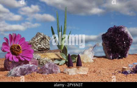 Chakra-Steine und Blumen auf australischem rotem Sand Stockfoto