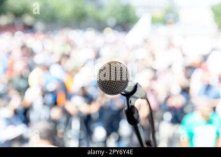 Konzentrieren Sie sich auf das Mikrofon, verschwommene Gruppe von Menschen bei Massenprotesten Stockfoto