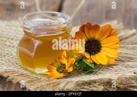 Honig und Blumen auf Holzhintergrund Stockfoto