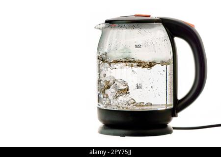 Elektrischer Wasserkocher aus Glas mit kochendem Wasser auf einem weißen, isolierten Hintergrund Stockfoto