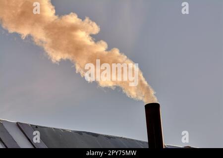 Rauch kommt aus dem Schornstein der Bourgeoisie, der Ofen wird erhitzt. Stockfoto