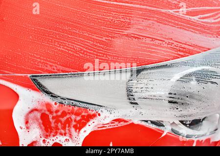 Details zu rotes Auto vorne Licht in der Waschstraße gewaschen. (Farbe kann leicht mit Farbton/Sättigung Tool geändert werden) Stockfoto