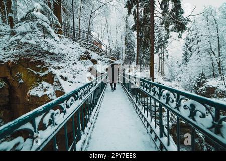 Ein Mann auf der Brücke im verschneiten Bergpark Stockfoto