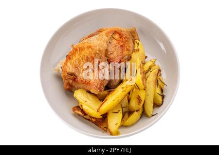 Gebratene Hähnchenschenkel mit gebackenen Kartoffeln auf weißem Teller isoliert auf weißem Boden mit Schnittpfad Stockfoto