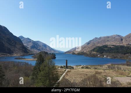 Das Glenfinnan-Denkmal erinnert an diejenigen, die für die Sache der Jakobiten starben, mit Blick auf Loch Shiel. Das Denkmal ist mit einer Statue eines Highlanders gekrönt Stockfoto