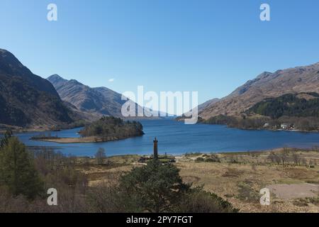 Das Glenfinnan-Denkmal erinnert an diejenigen, die für die Sache der Jakobiten starben, mit Blick auf Loch Shiel. Das Denkmal ist mit einer Statue eines Highlanders gekrönt Stockfoto