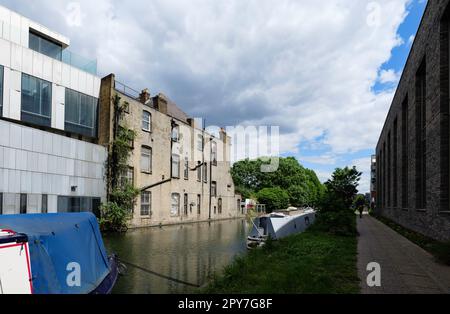 London - 05 21 2022: Hausboote, die auf dem Canal Grande in der Nähe der Adela Street festgemacht sind, mit Stockenten im Flug Stockfoto