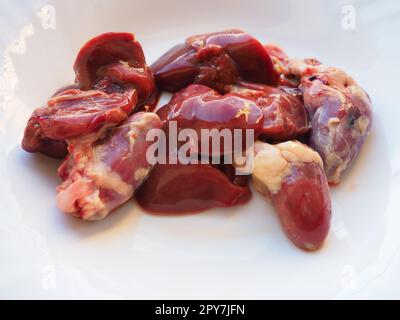 Rohe Hühnerleber, Nieren und Herz. Eingeweide und Schlachtnebenerzeugnisse von Geflügel, zubereitet zum Kochen Eine eisenhaltige Diät gegen Anämie. Fleisch auf weißem Hintergrund Stockfoto